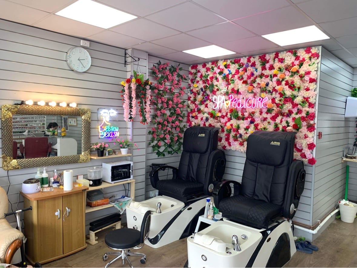 Pedicure chairs beside the flower wall inside Jessica Nails